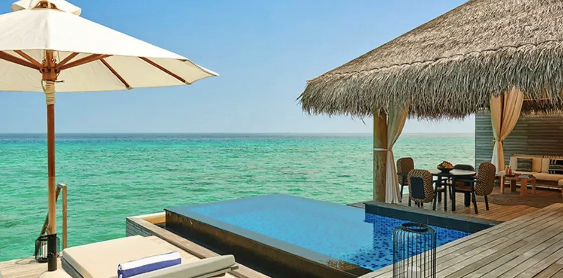 Privater Pool auf einer Holzterrasse mit Blick auf das türkisblaue Meer.