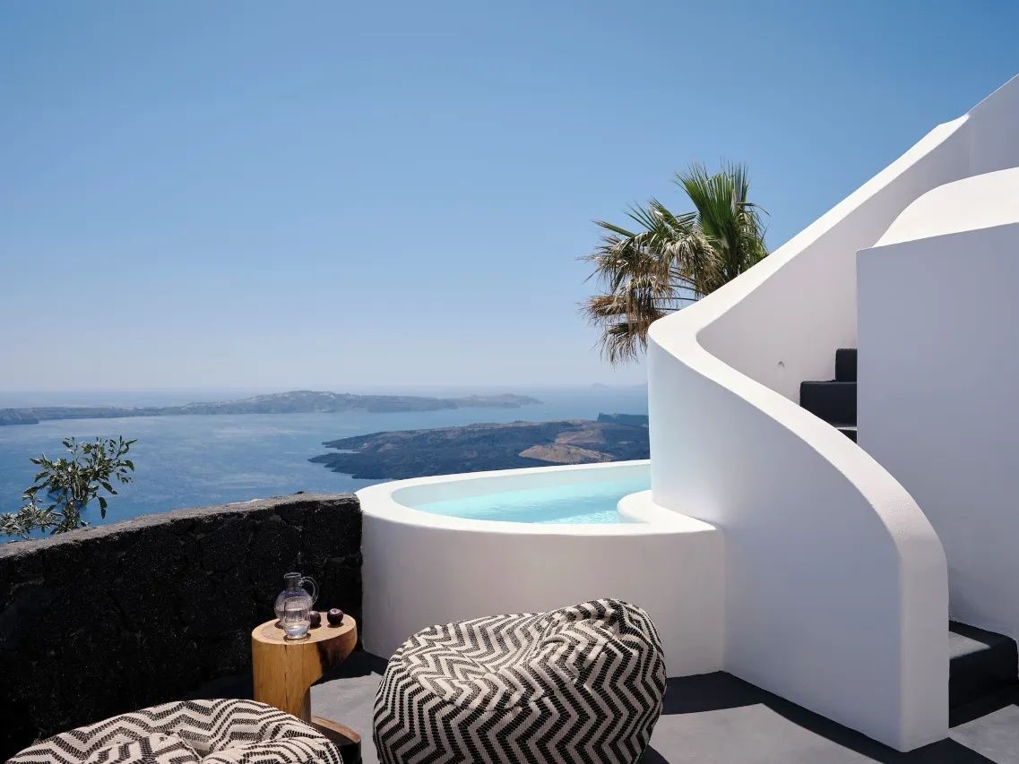 Terrasse mit Sitzsäcken, kleinem Pool und weitläufigem Blick auf das Meer und Inseln.