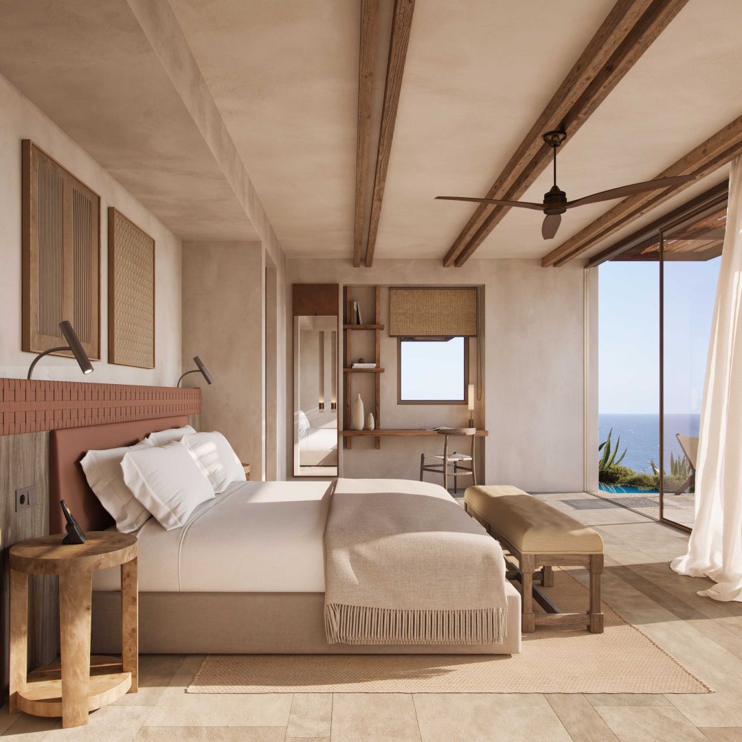 Heller Schlafbereich mit Doppelbett, Holzbalken an der Decke und Blick auf das Meer.