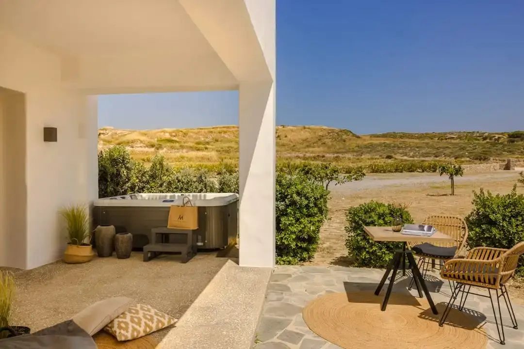Überdachte Terrasse mit Whirlpool, Sitzbereich und Blick auf die umliegende Landschaft