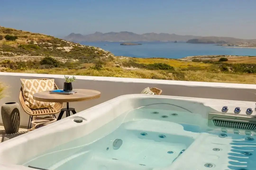 Whirlpool auf einer Terrasse mit Blick auf das Meer und die gegenüberliegenden Inseln.