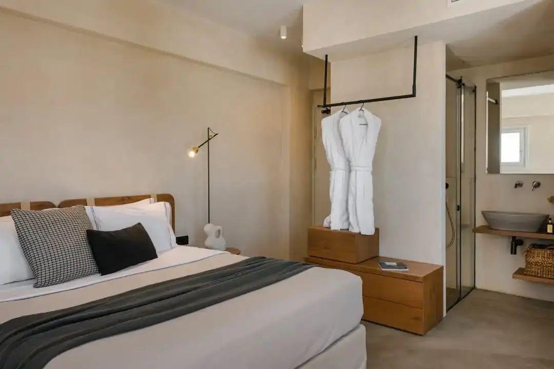 Modernes Zimmer mit Doppelbett und offenem Kleiderständer mit Bademänteln.