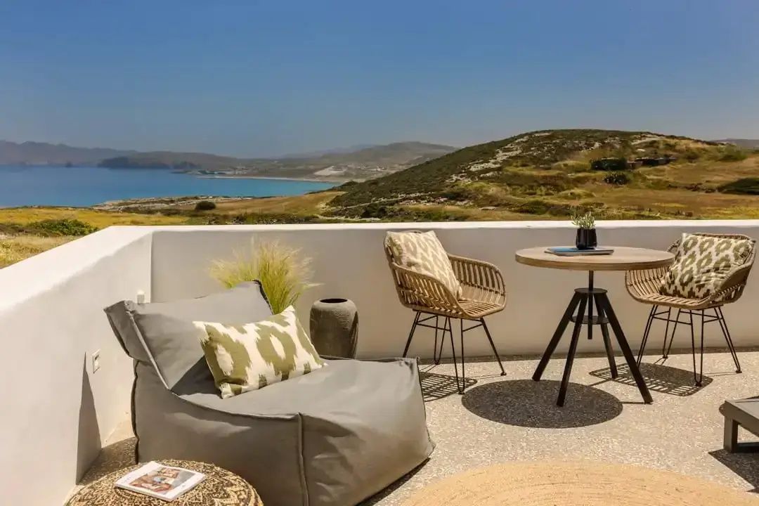 Terrasse mit Sitzsack und Tisch mit Blick auf das Meer und Hügel.
