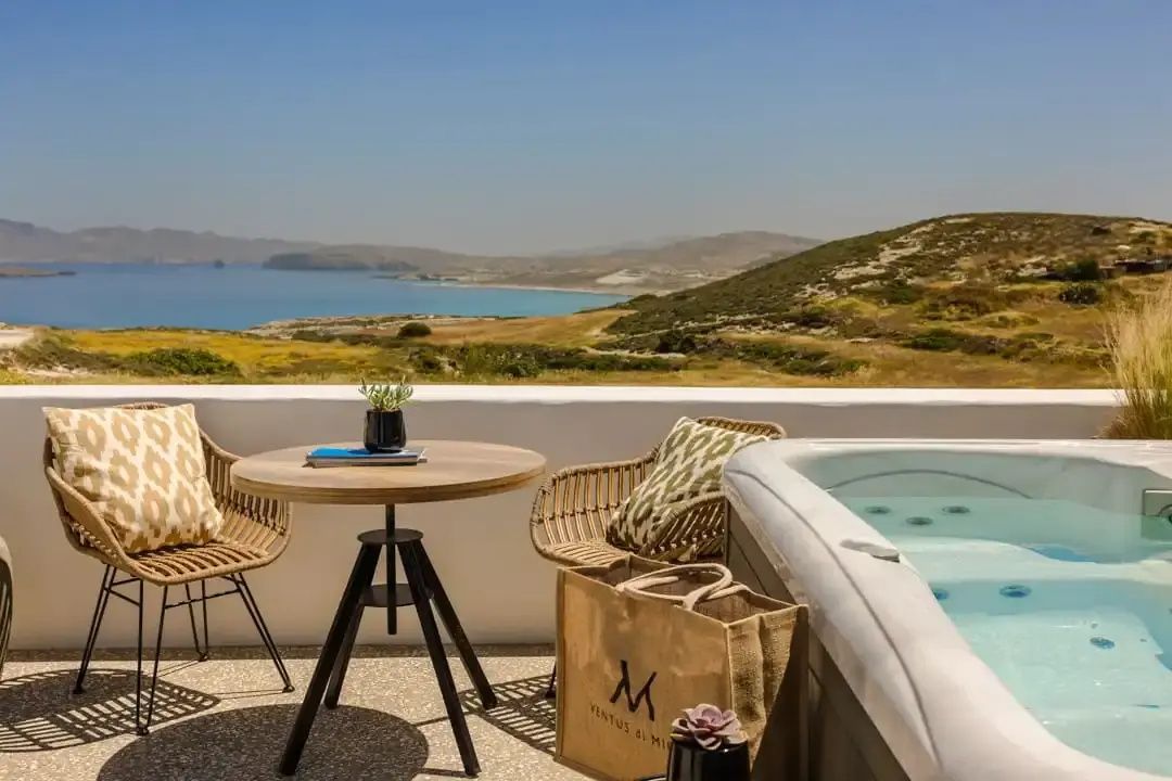 Terrasse mit Whirlpool, Bistro-Tisch und Aussicht auf die Küste.