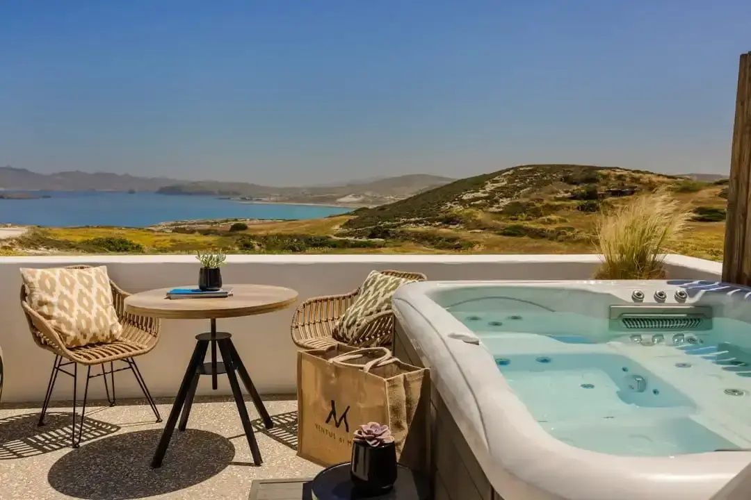 Whirlpool auf einer Terrasse mit Sitzgelegenheit und Blick auf das Meer.