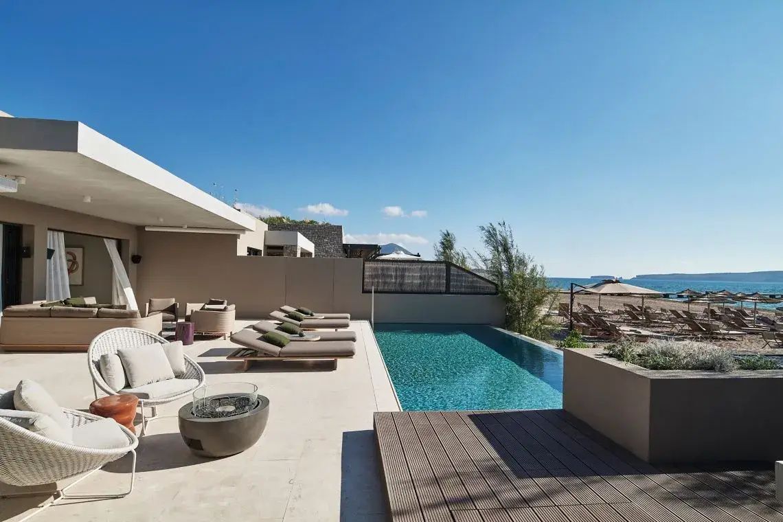 Terrasse mit privatem Außenpool, Sonnenliegen und Blick auf den Strand und das Meer.