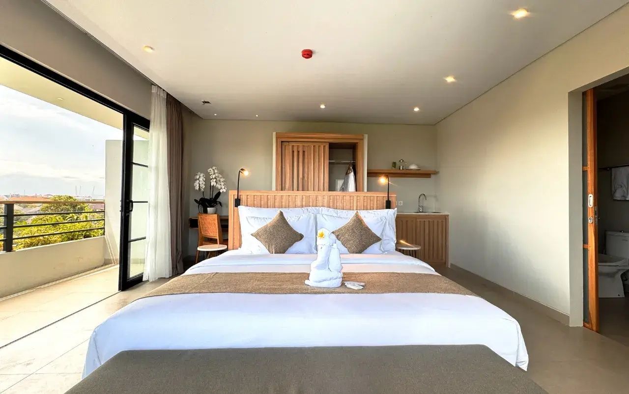 Gemachtes Doppelbett mit Handtuchdekoration und hellem Holzschrank.