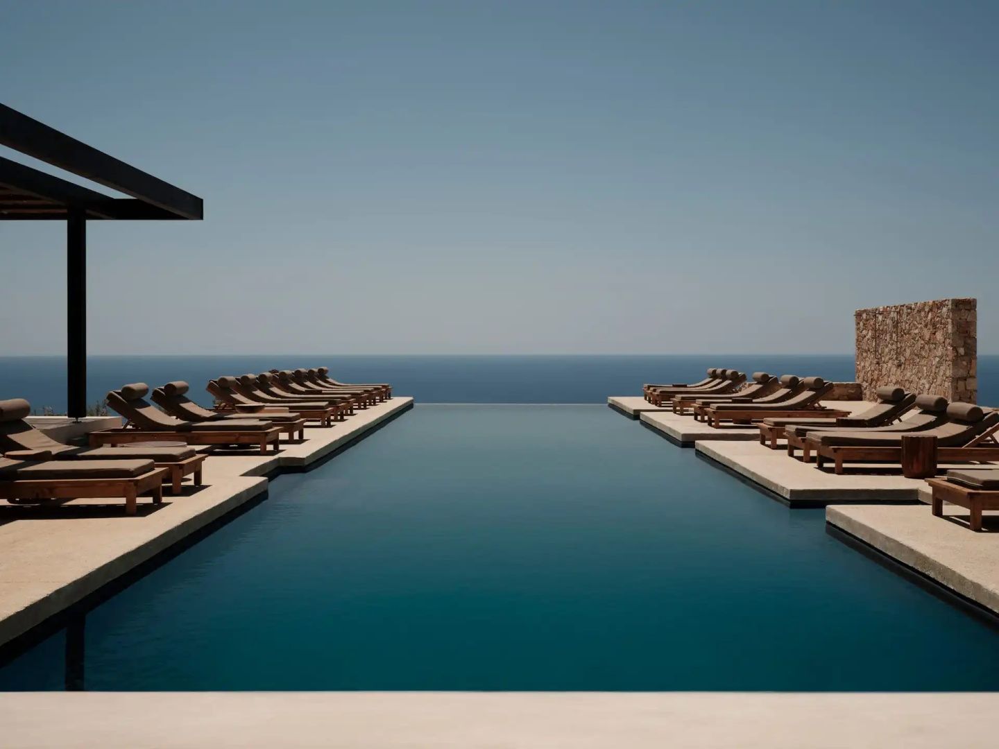 Boutique Hotel in Griechenland: Infinity-Pool mit Holzliegen über dem Meer im Gundari auf Folegandros