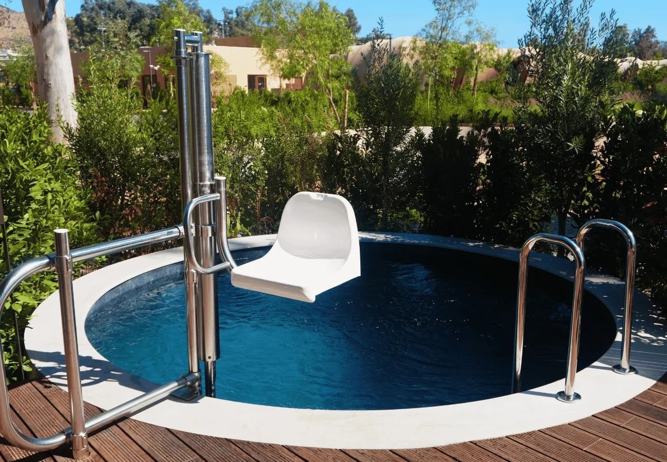Runder Außenpool mit einem barrierefreien Poollifter und Holzdeck.