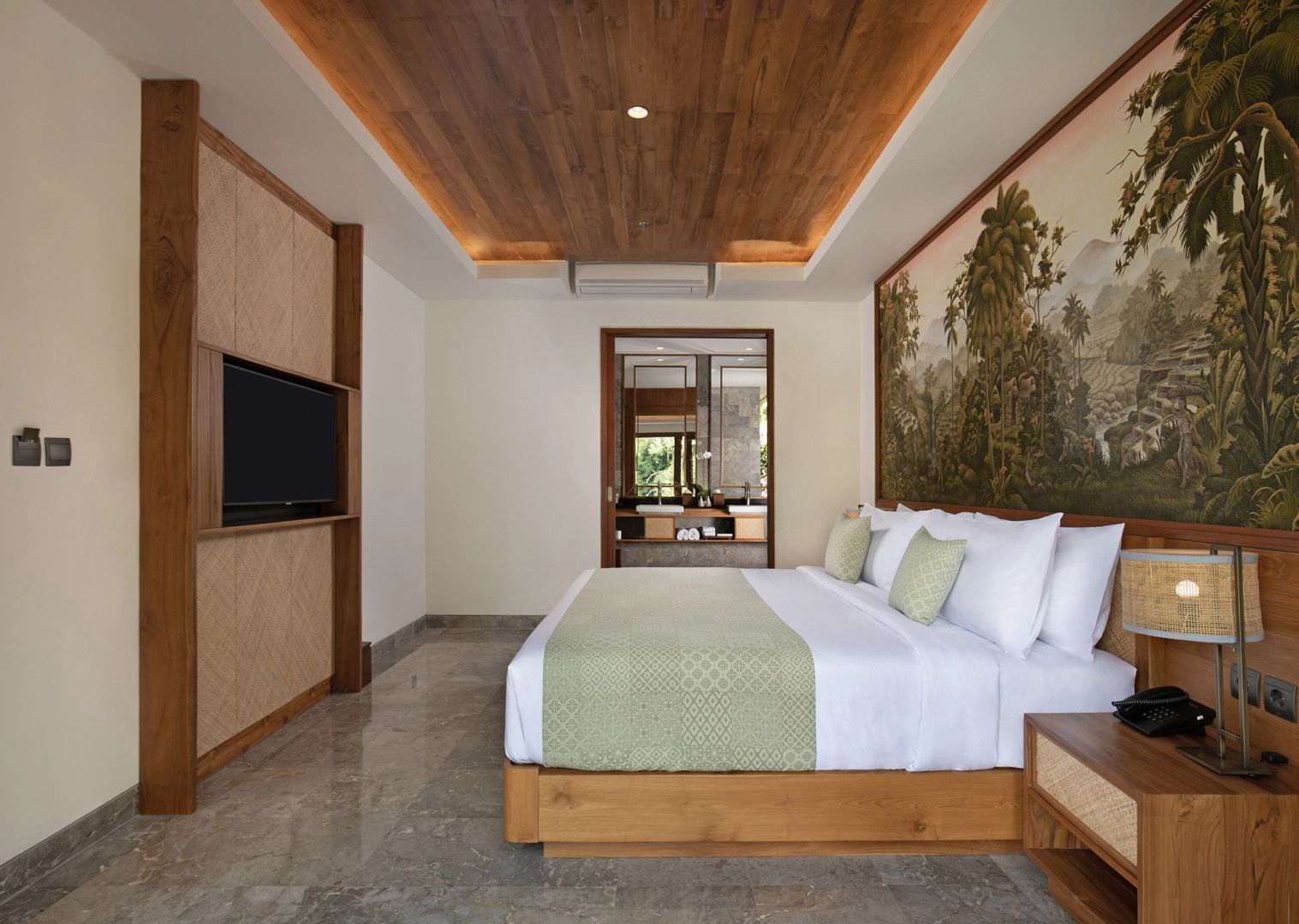 Schlafzimmer mit großem Doppelbett, Holzdecke und Wandbild sowie Blick ins Badezimmer.