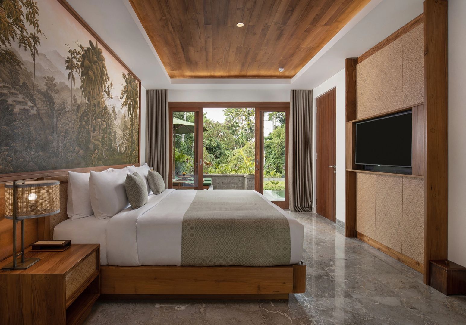 Helles Hotelzimmer mit Doppelbett, Wandgemälde und Terrassentür zum grünen Garten.
