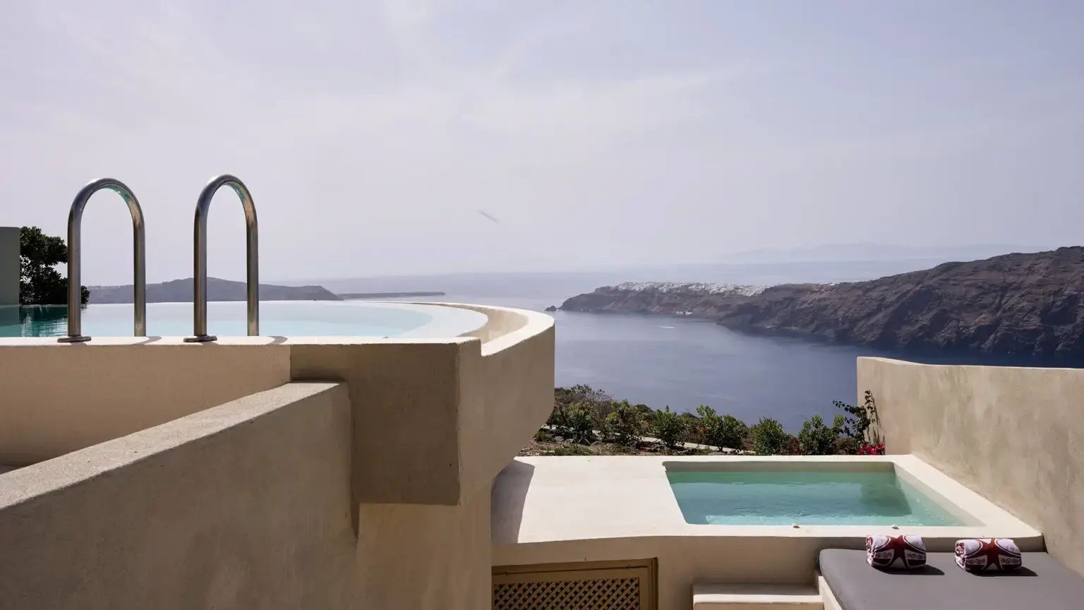 Ein Pool auf einer hoch gelegenen Terrasse mit weitem Blick über das Meer und die Insel.