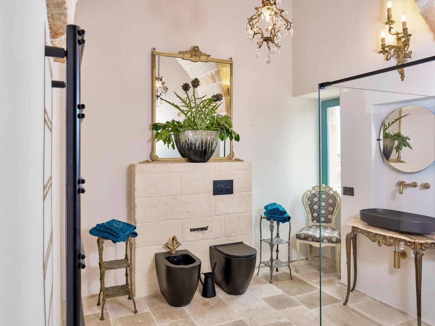 Badezimmer mit schwarzem WC und Bidet, großem Spiegel, Pflanzen und hellem Fliesenboden.