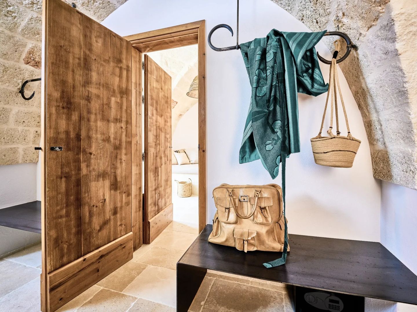 Eingangsbereich einer Suite mit Garderobe, Holztüren und einer dunklen Sitzbank.