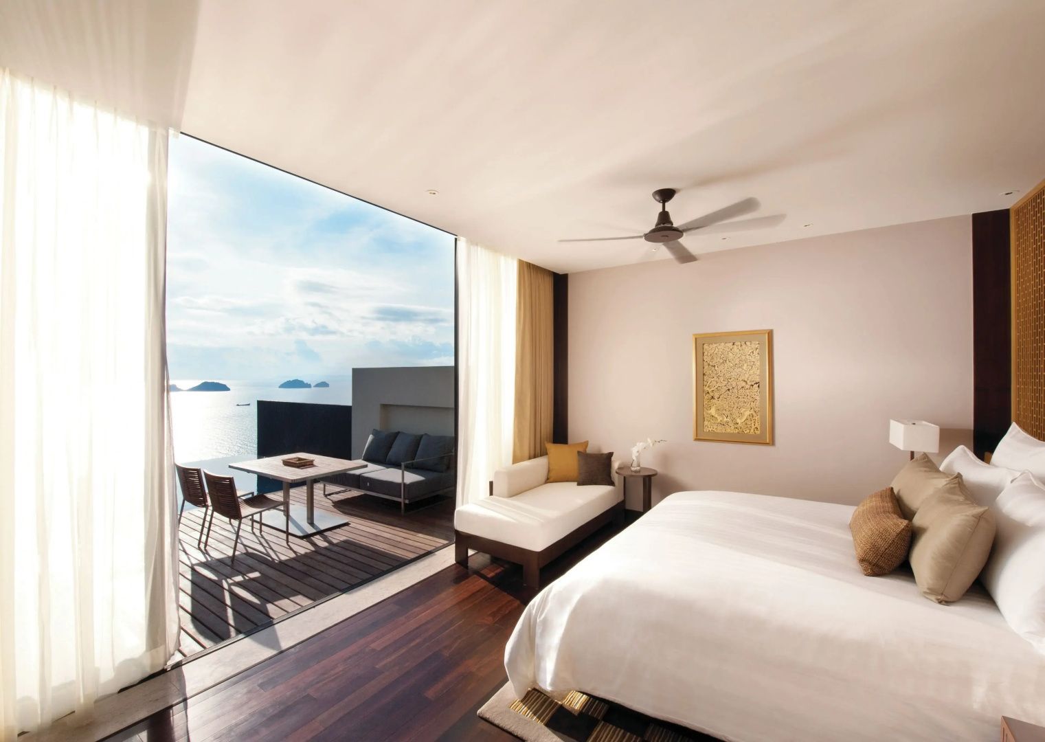 Helles Schlafzimmer einer Villa mit großem Doppelbett und angrenzender Terrasse mit Meerblick.