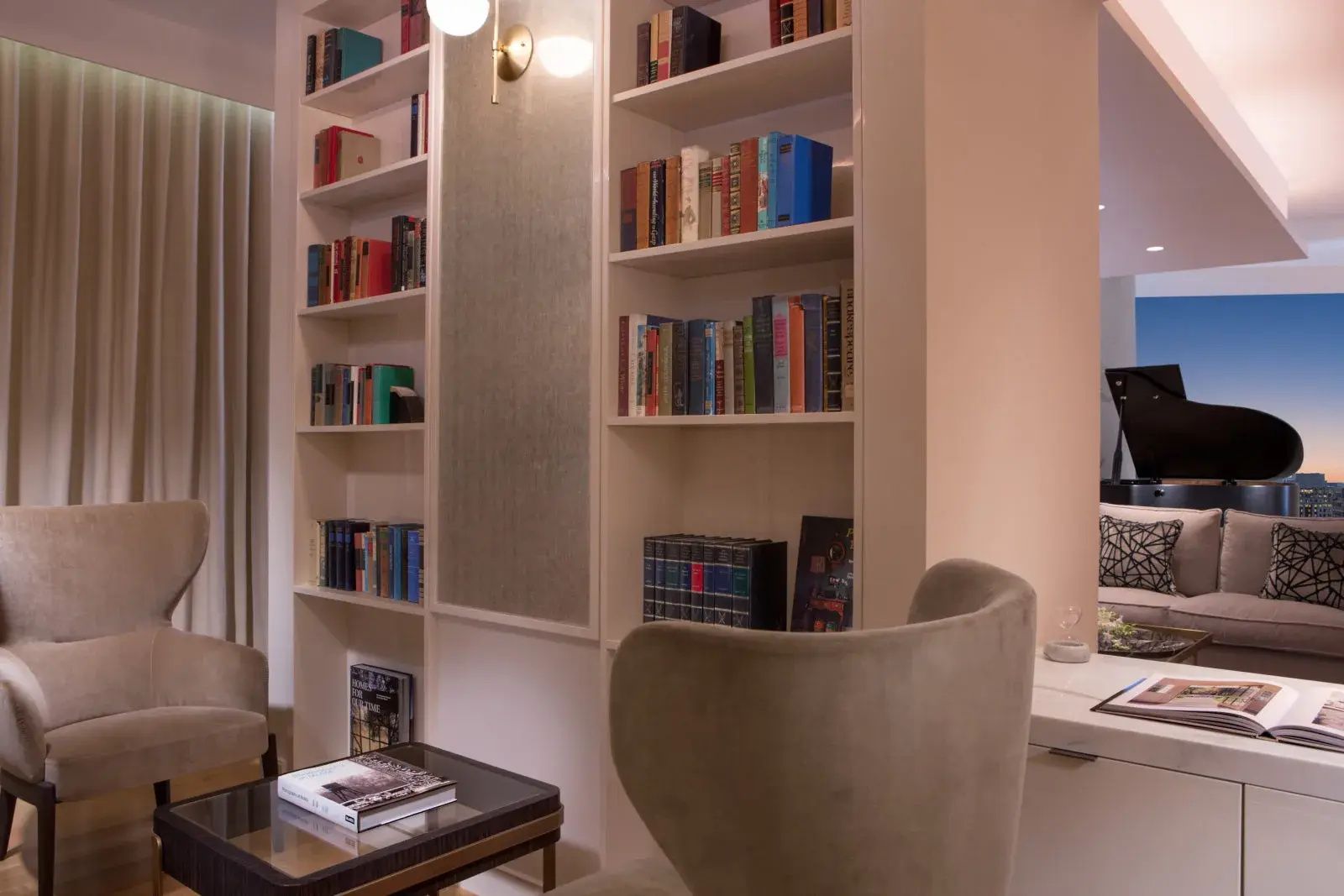 Bücherregal in einer Leseecke mit Sessel, Wandleuchte und kleinem Beistelltisch.