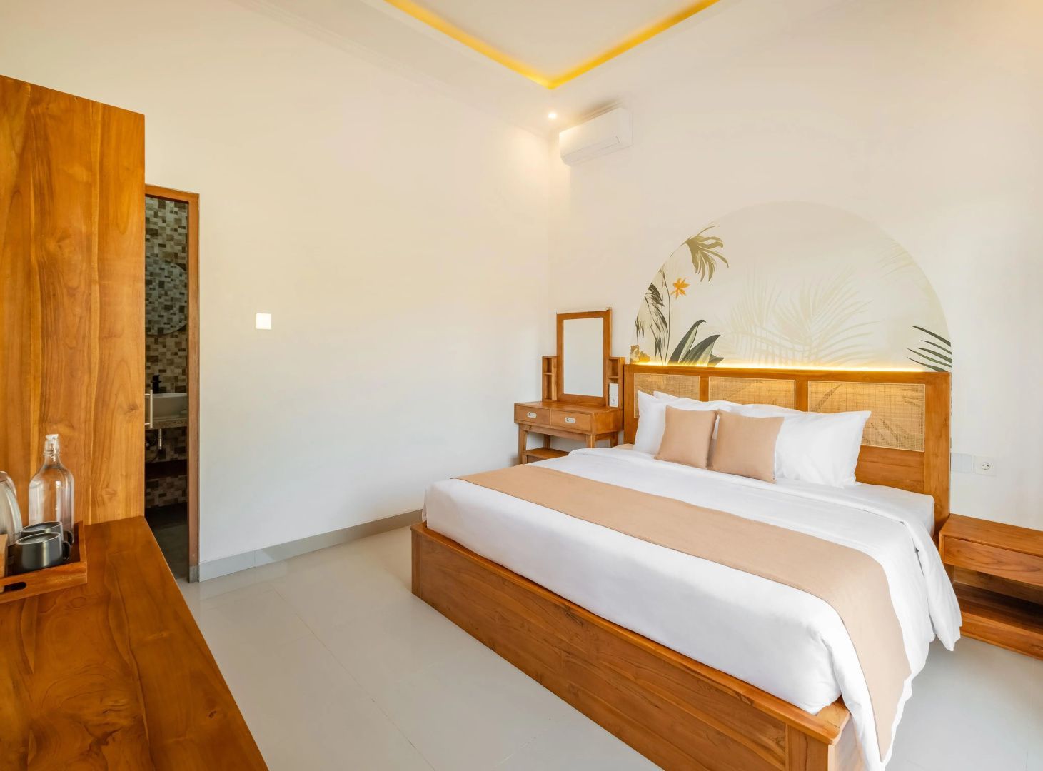 Schlafzimmer mit großem Holzdoppelbett und Blick zum Badbereich.