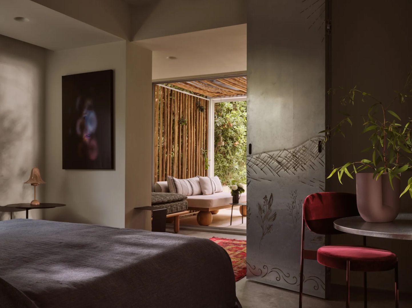 Blick aus einem modern eingerichteten Hotelzimmer auf eine überdachte Veranda.
