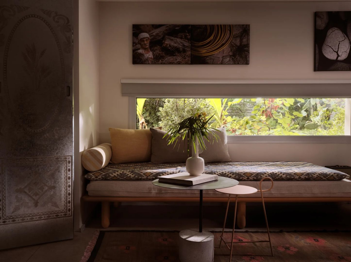 Gemütliches Daybed unter einem Panoramafenster mit Blick in den Garten.