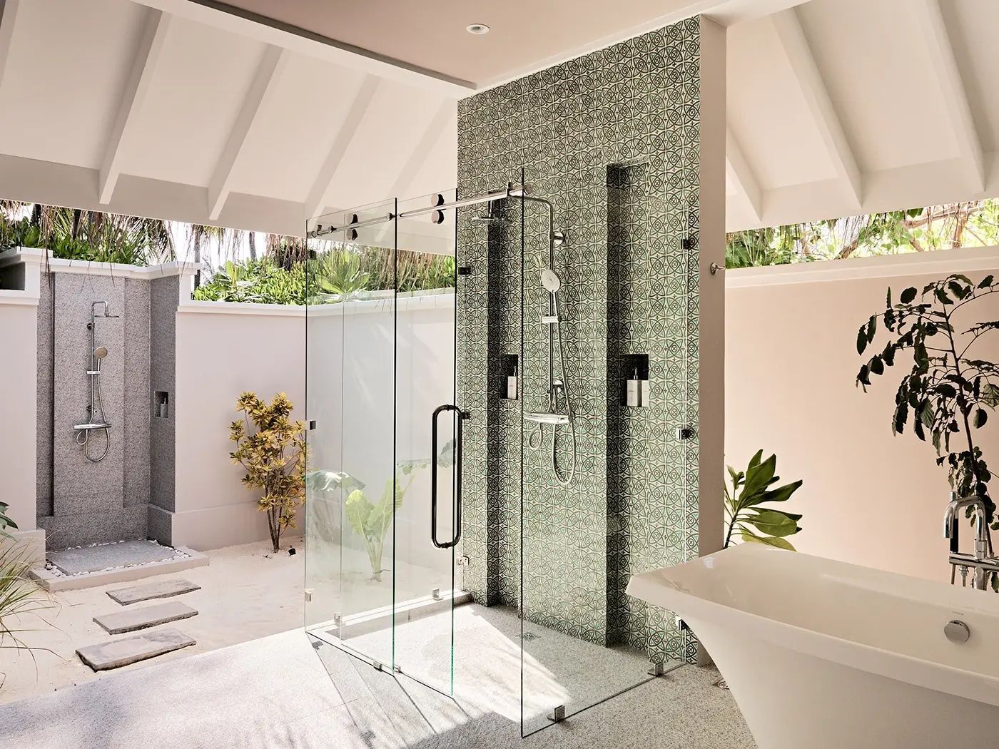 Offenes Badezimmer mit einer Glasdusche, einer freistehenden Badewanne und grünen Mosaikfliesen.
