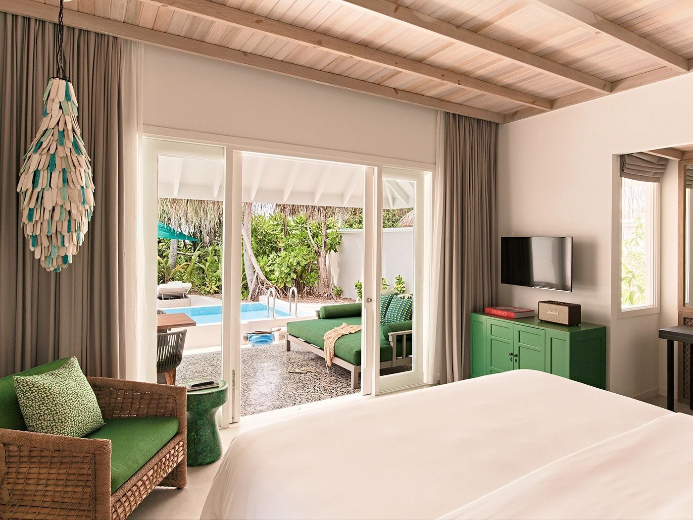 Helles Hotelzimmer mit Blick durch die geöffnete Terrassentür auf den privaten Pool im Außenbereich.