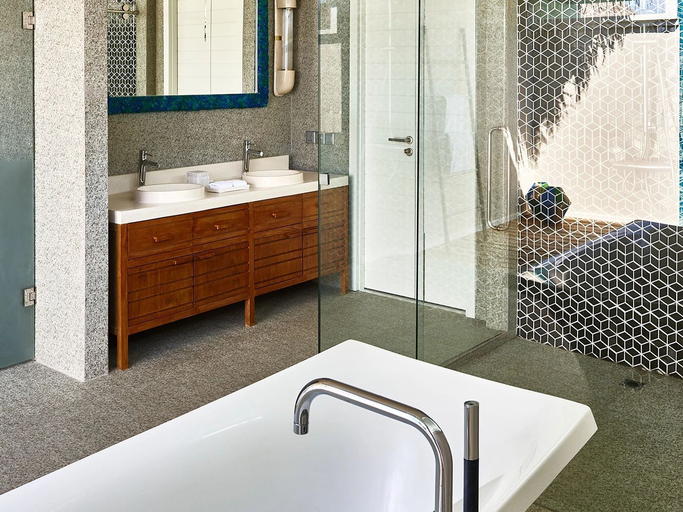 Badezimmer mit Doppelwaschtisch aus Holz, freistehender Badewanne und Glasdusche.