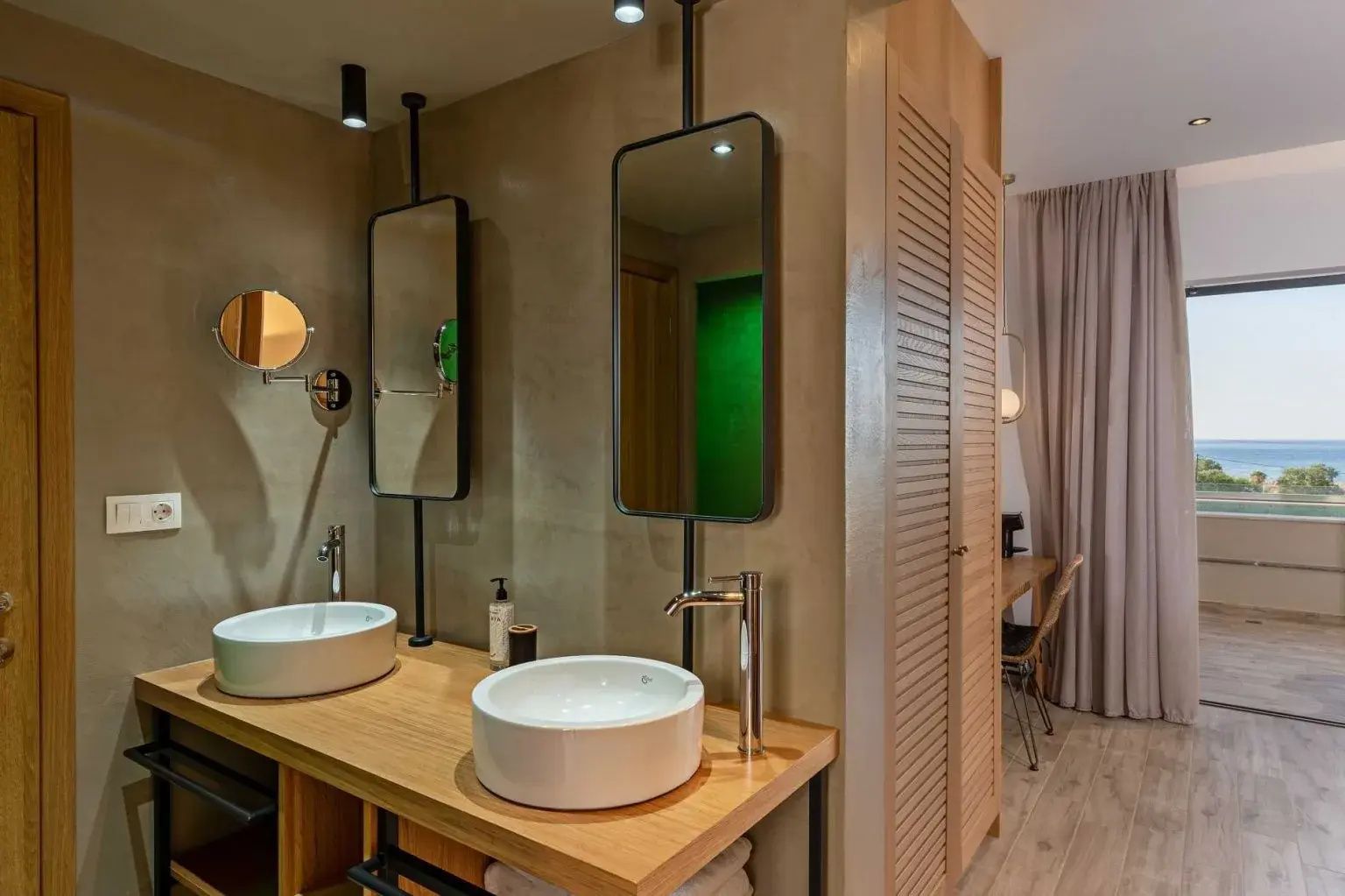 Modernes Badezimmer mit Doppelwaschtisch, zwei runden Waschecken und an der Decke montierten Spiegeln.