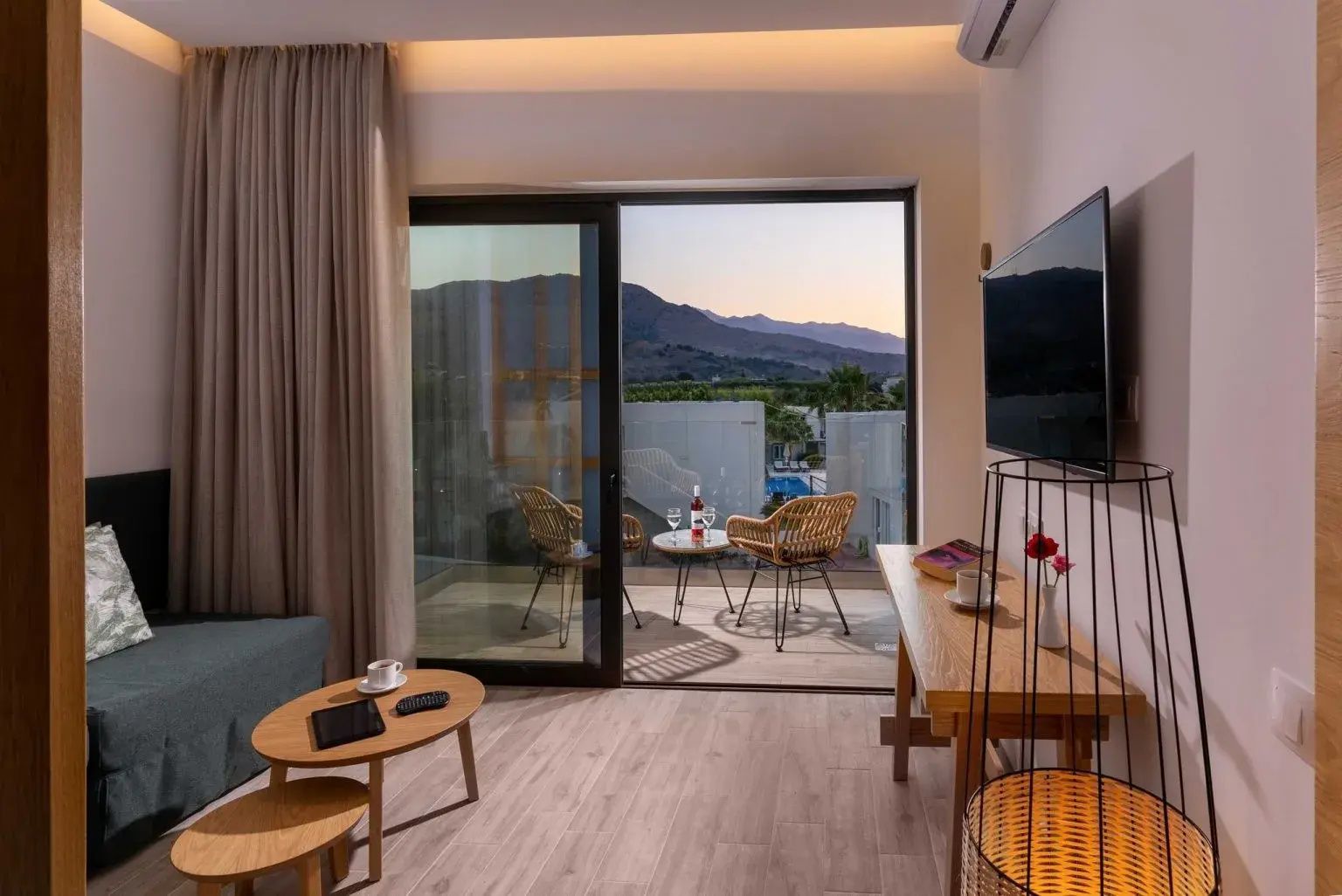 Blick vom Hotelzimmer über den Balkon auf die umliegende Landschaft und Berge.