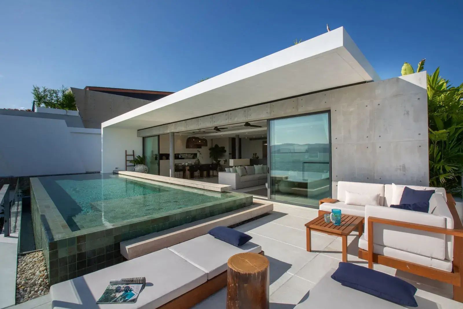 Außenbereich der Villa mit privatem Pool, Sitzmöbeln und Ausblick auf das Meer.