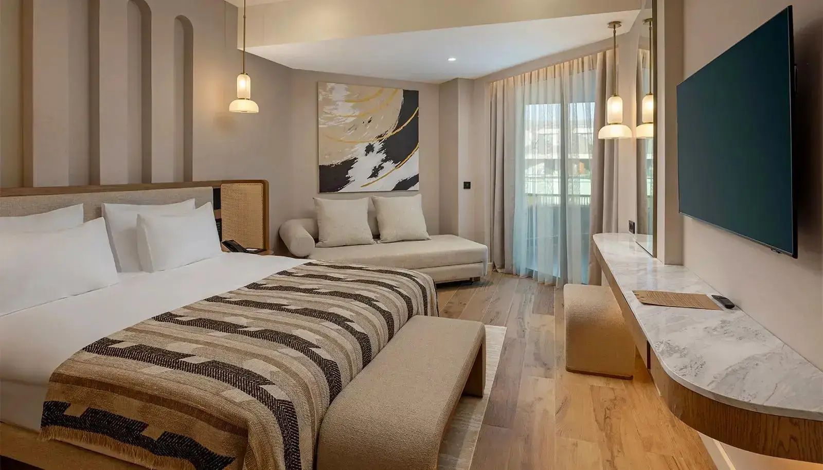 Modern eingerichtetes Hotelzimmer mit Doppelbett, Chaiselongue und Vorhängen am Fenster.