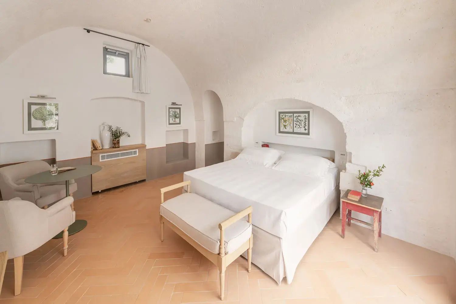 Helles Doppelzimmer mit Nische, Holzbank und Fliesenboden in Erdtönen