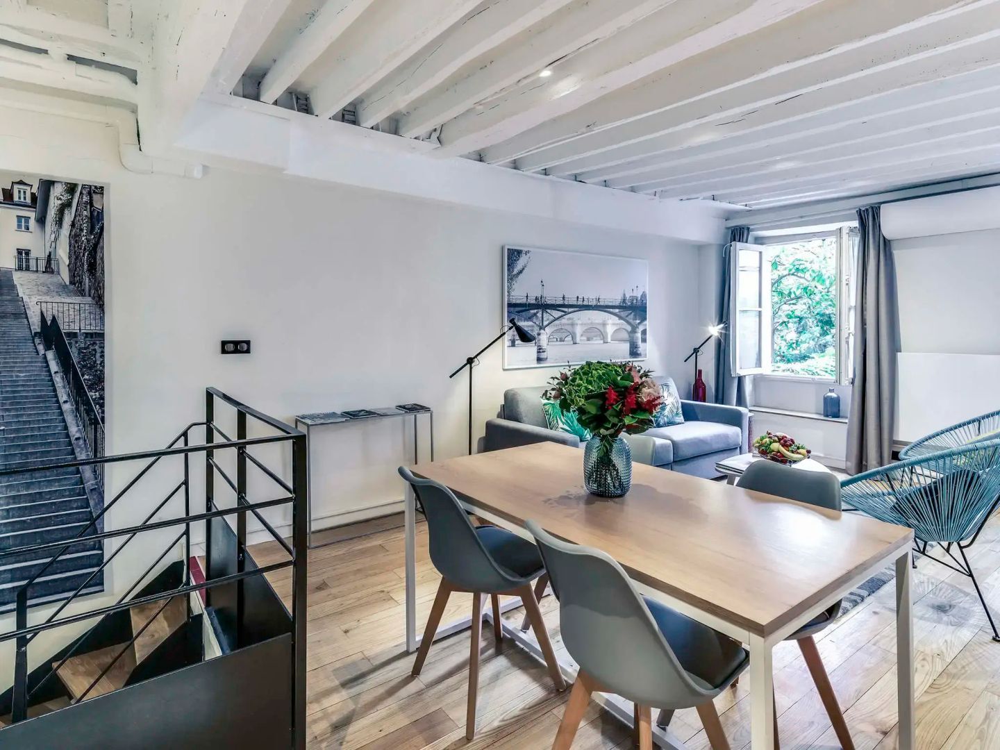 Esstisch mit Stühlen und Sofa in einer geräumigen Suite mit Parkettboden