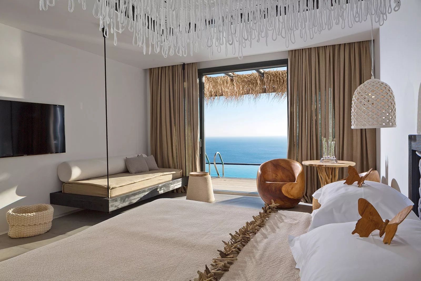 Blick aus dem Zimmer über die eigene Terrasse mit Pool auf das blaue Meer.