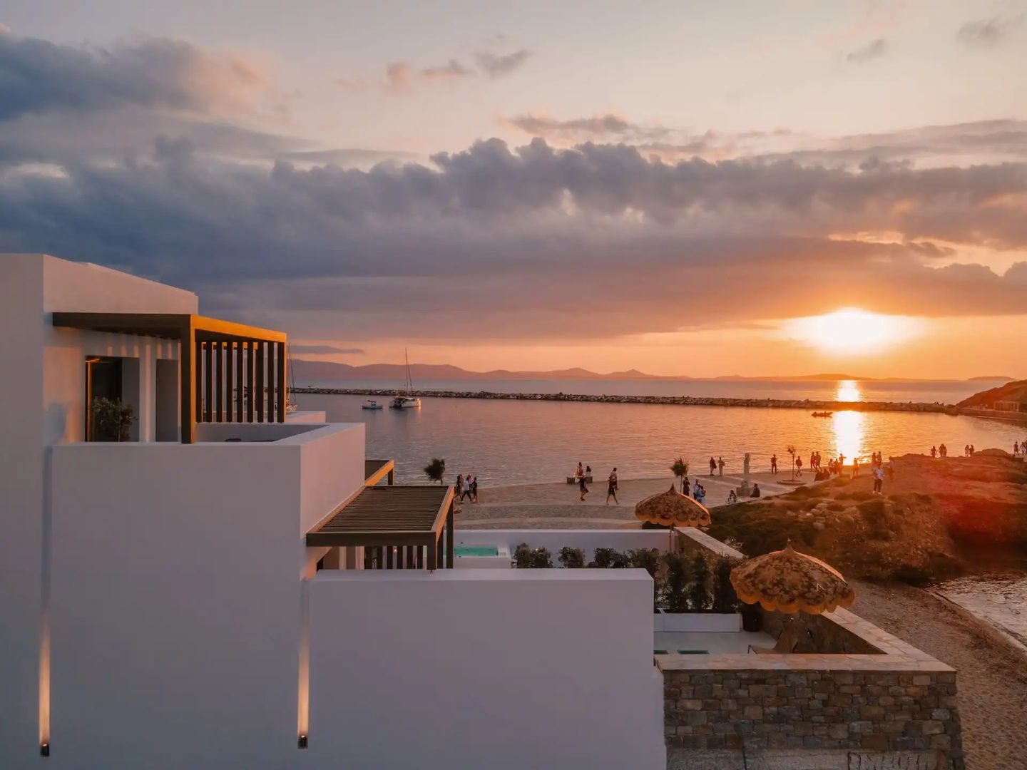 Blick von einer Terrasse bei Sonnenuntergang auf das Meer und den Strand