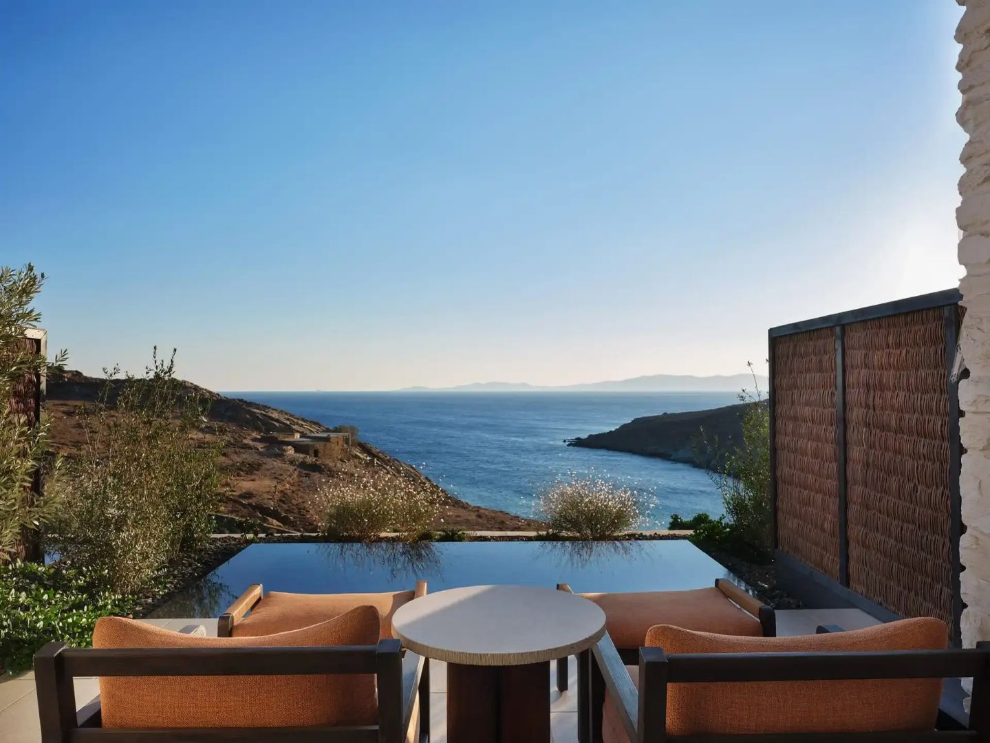 Terrasse mit zwei Sesseln und privatem Pool mit Blick auf die Bucht und das Meer