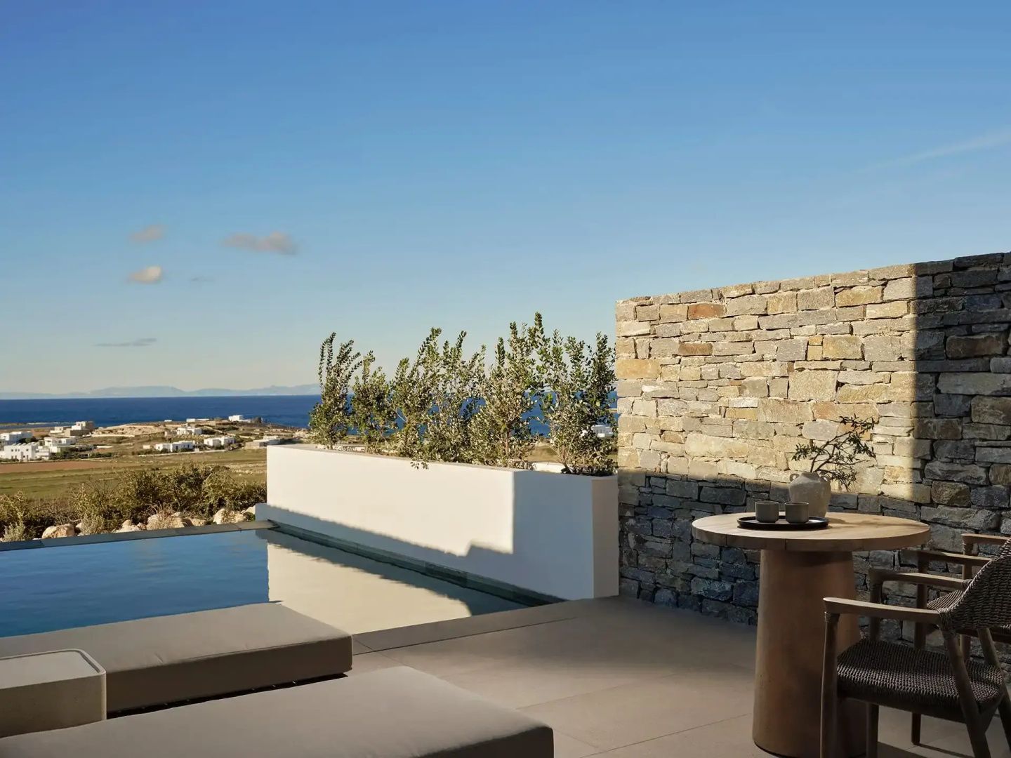 Terrasse mit privatem Pool, Sonnenliegen und Blick auf die Aegaeis.