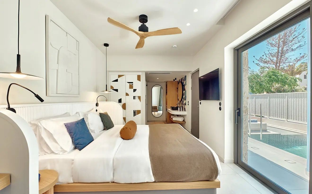 Hotelzimmer mit Bett, TV an der Wand, Schrankwand und Blick in den Eingangsbereich.