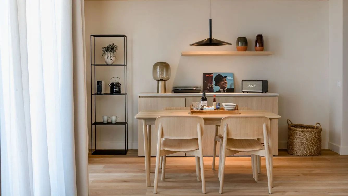 Essbereich in einer Suite mit Holztisch, Stühlen und dekorativem Sideboard.