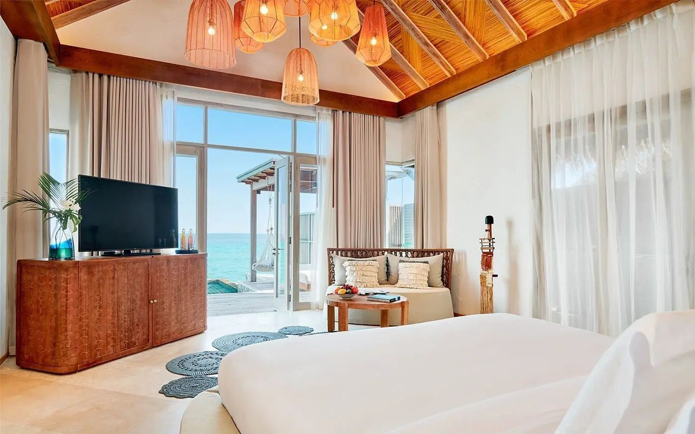 Schlafbereich einer Villa mit Doppelbett und weitreichendem Blick auf den Ozean