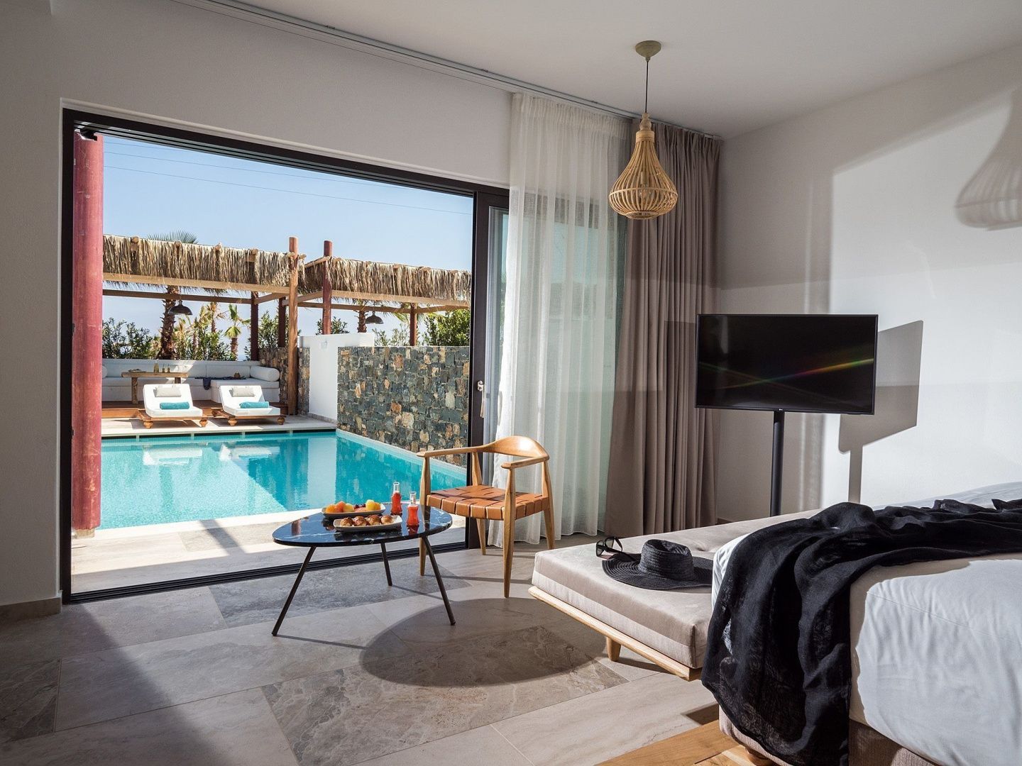 Blick aus dem Hotelzimmer über die private Terrasse direkt auf einen Swimmingpool im Außenbereich.