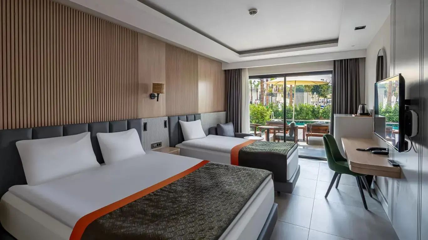 Modernes Hotelzimmer mit zwei Betten, Holzverkleidung an der Wand und Zugang zur Terrasse.