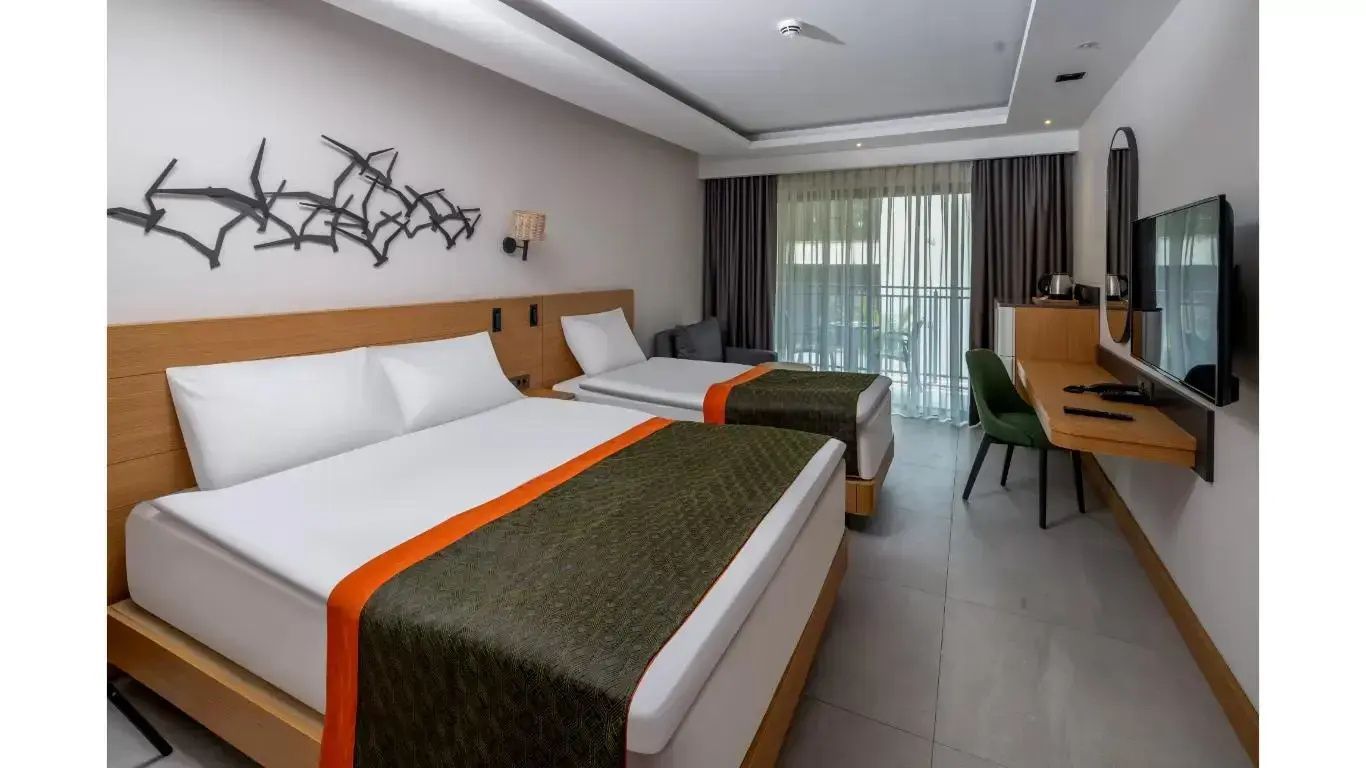 Hotelzimmer mit einem Doppelbett, einem Einzelbett und Zugang zum Balkon