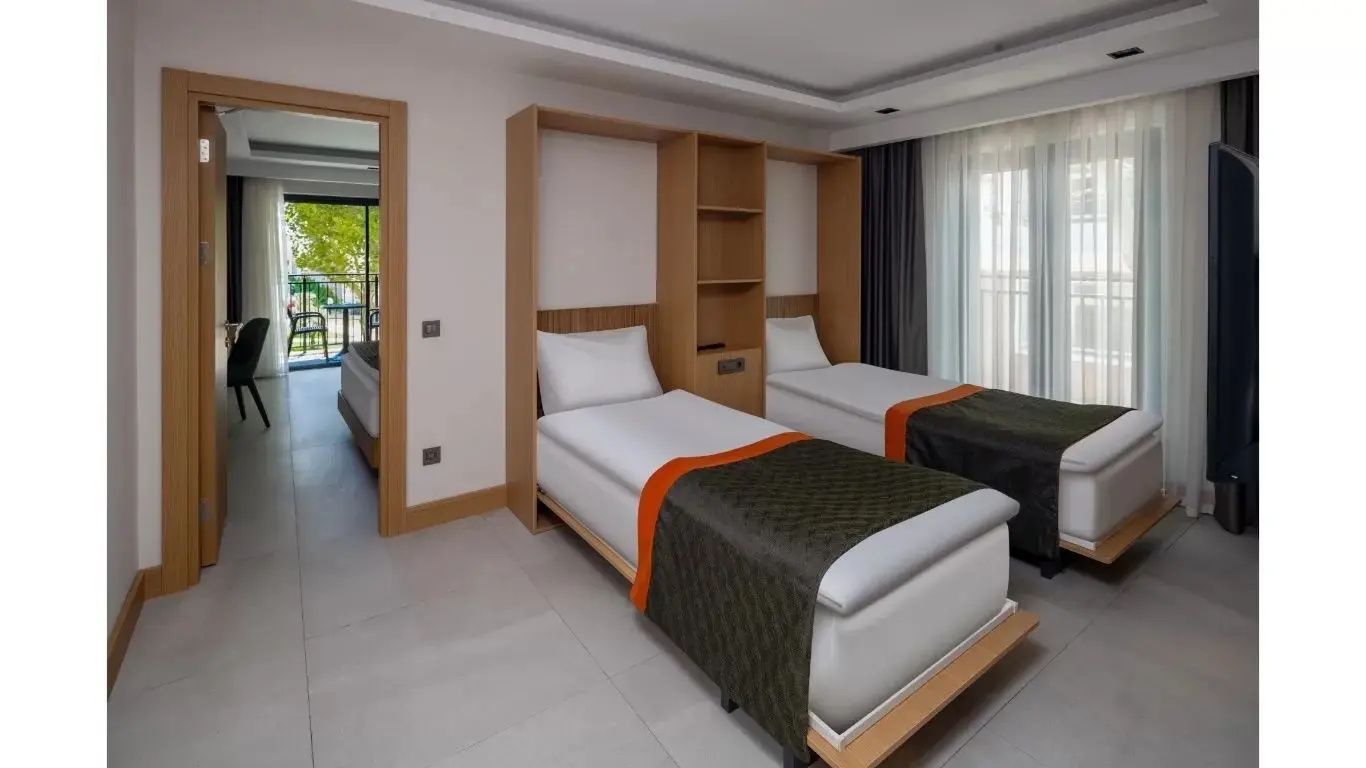 Schlafbereich mit zwei Einzelbetten und Holzregal im Hotelzimmer.