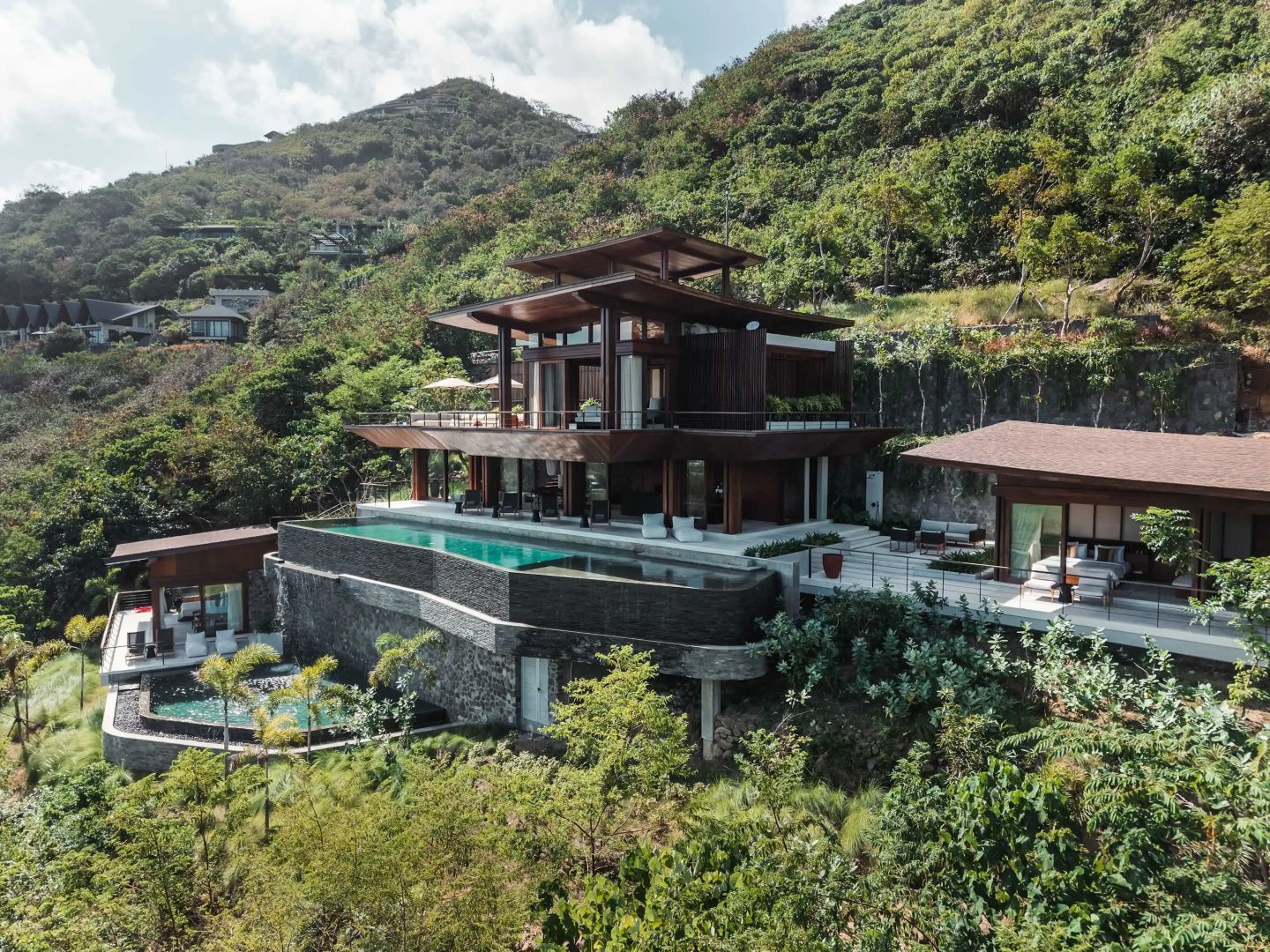 Mehrstöckige Holzvilla am grünen Hang mit Swimmingpool und Sonnendeck