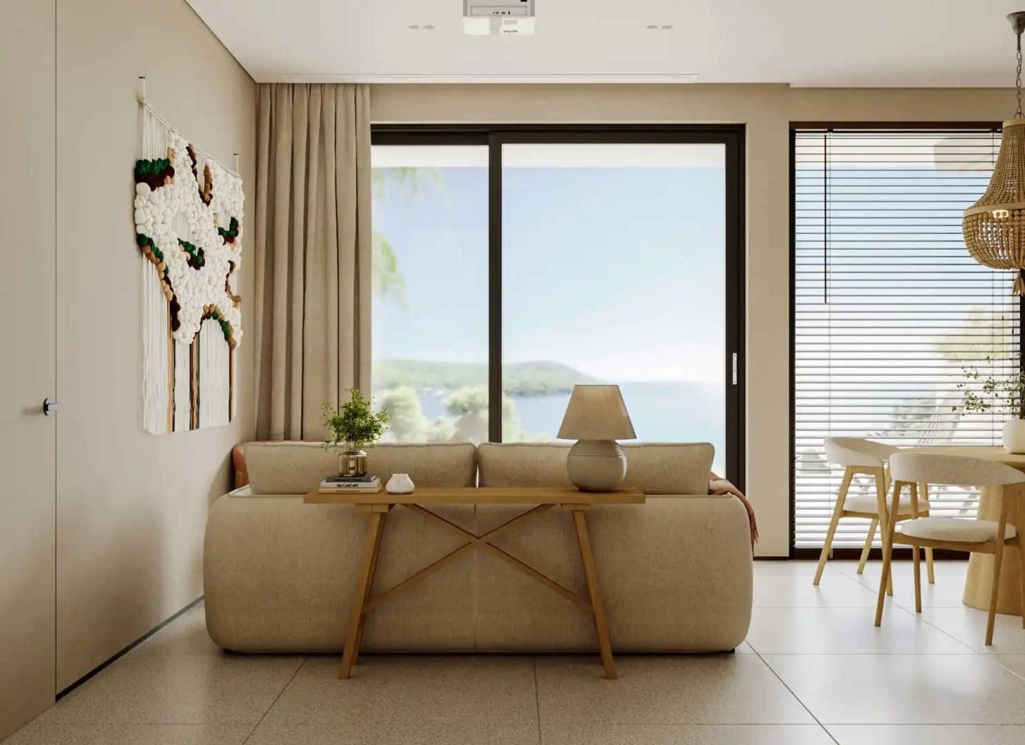 Wohnbereich mit hellem Sofa und großer Glasfront mit Blick auf das Meer und die Küstenlandschaft.