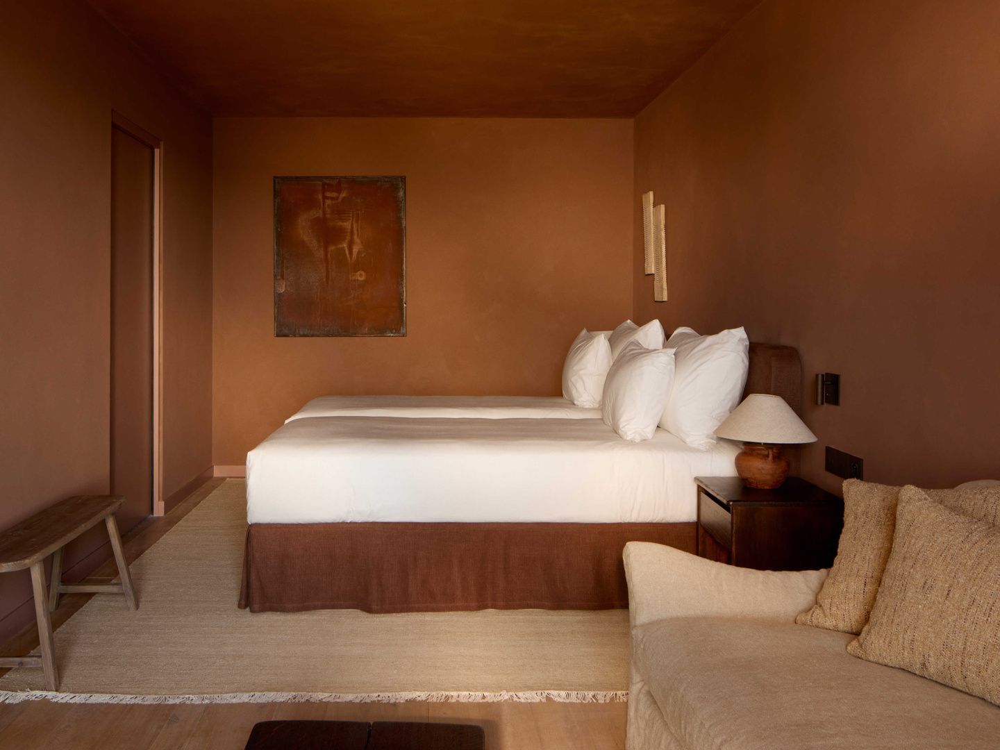 Schlafzimmer mit braunen Wänden, einem großen Bett und hellem Teppich.