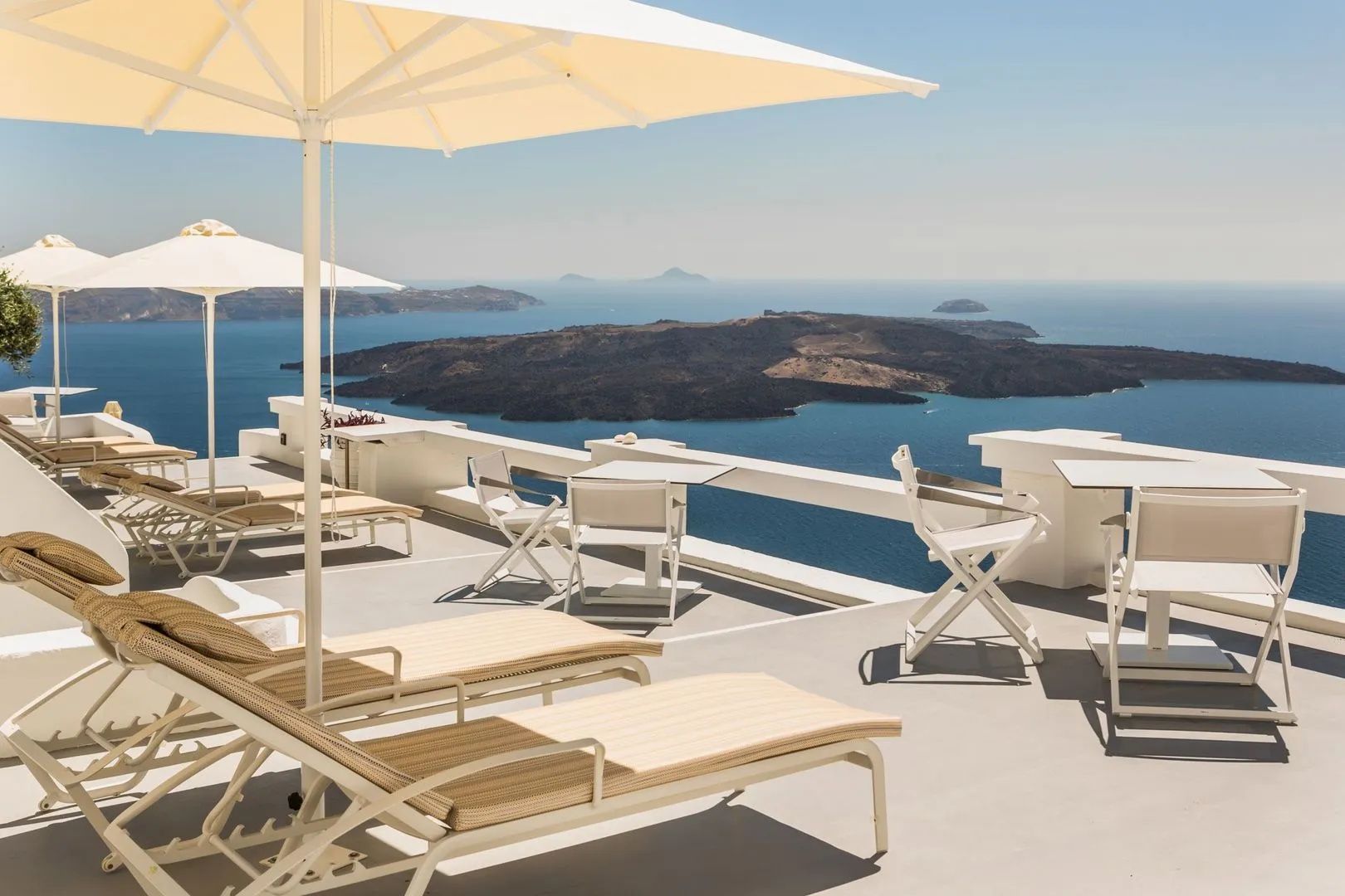 Pool mit Liegen und Sonnenschirmen auf der Caldera-Terrasse des Sun Rocks Boutique Hotel auf Santorin
