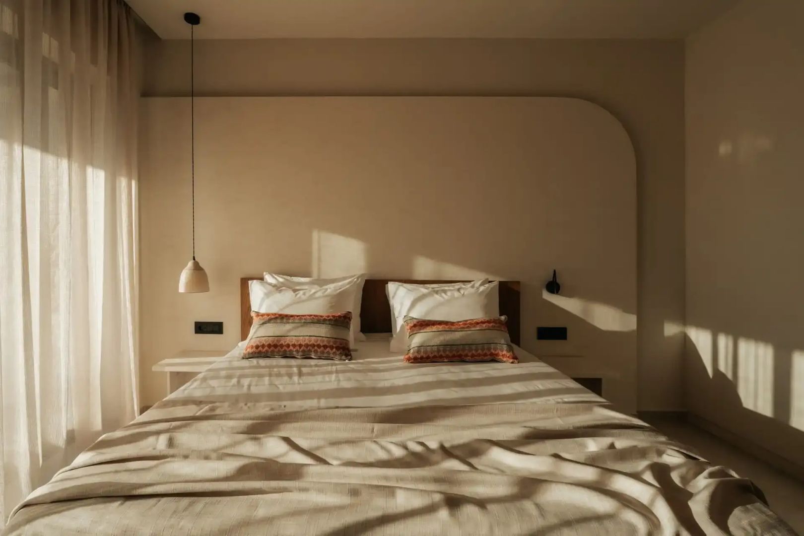 Doppelbett mit Kissen und natürlichem Lichteinfall im Schlafzimmer.