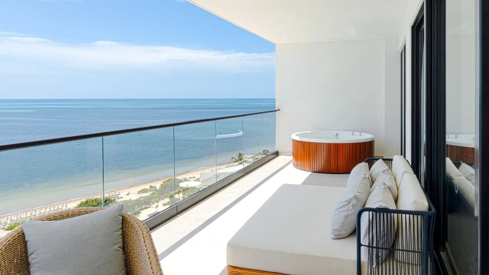 Balkon mit Whirlpool und Tagesbett bietet Panoramablick auf das blaue Meer und die Küste.