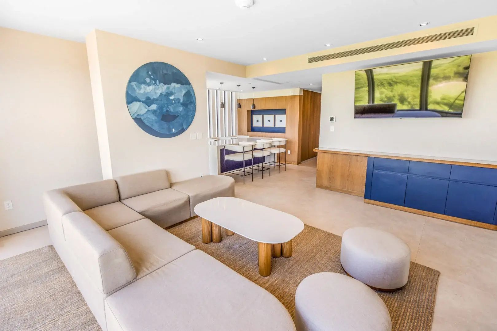 Wohnbereich einer Suite mit hellem Ecksofa, Couchtisch und kleiner Bar im Hintergrund